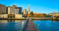 Aerial over Pier 7 sunrise golden glow over city skyscrapers with blue sky