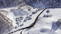 Aerial over winter wonderland, snowy village in sunny winter day.Winterland scene with lodges and cottages near small