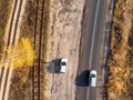 Aerial overhead top down bird eye drone view of asphlat rural country road with parked and driving cars at evening or Royalty Free Stock Photo