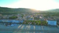 Aerial pan left shot from Cupra Marittima with lens flare, waves, beach, buildings, trees, hills, breakwaters