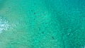 Aerial Pan Upwards shot of bodyboarders catching waves in clear tropical ocean