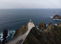 Aerial panorama of Cabo Ortegal lighthouse on steep rocky cliff atlantic ocean bay of biscay Carino Cape Galicia Spain