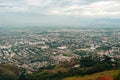 Aerial panorama of the city of Cali taken from the top of Cristo del Rey against a blue sky. Colombia