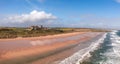 Aerial panorama landscape of Bamburgh Castle and sand dunes in Northumberland Royalty Free Stock Photo