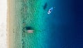 Aerial panorama of Mediterranean sea coast with white sand beach and blue water. Top view of sail boat and pier with copy space