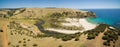 Aerial panorama of Middle River flowing to the ocean via Snelling Beach among yellow hills on Kangaroo Island, South Australia.