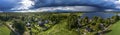 Aerial Panorama of Scandinavian pine tree forest landscape, summer village with Sunny and rainy areas, clear blue sky, white Royalty Free Stock Photo