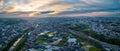 Aerial panorama: Sunrise over river and train tracks through sprawling suburban rural area Royalty Free Stock Photo