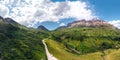 Aerial panorama view of the road for travelers on a motorcycle, car, incredible beauty views of green meadows and majestic