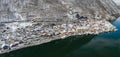 Aerial panoramic drone shot of snowy Hallstatt village by lake in Austria during winter time Royalty Free Stock Photo