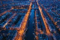 Aerial panoramic view of evening Amsterdam with water canals, illuminated roads and historic buildings, The Netherlands Royalty Free Stock Photo