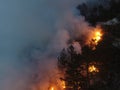 Aerial panoramic view of a forest fire at night, heavy smoke causes air pollution, and fire in full blaze. Natural