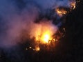 Aerial panoramic view of a forest fire at night, heavy smoke causes air pollution, and fire in full blaze. Natural