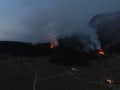 Aerial panoramic view of a forest fire at night, heavy smoke causes air pollution, and fire in full blaze. Natural