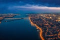 Aerial panoramic view of night city Voronezh with illuminated roads, bridges over river and high-rise buildings