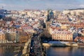 Aerial panoramic view from Old Town Bridge Tower, Karlov or Charles bridge and Vltava River in winter, sunny day, snow lies on red