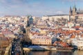 Aerial panoramic view from Old Town Bridge Tower, Karlov or Charles bridge and Vltava River in winter, sunny day, snow lies on red