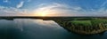 Aerial panoramic view shot by a drone of a beautiful dramatic and colorful sunset at coast of the lake. Nature landscape Royalty Free Stock Photo