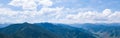 panoramic wide banner view of a Chike-Taman pass in the Altai mountains with green trees, Blue sky and clouds Royalty Free Stock Photo