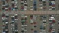 Aerial. Parking lots with a lot of cars and pedestrian crosswalk between them.