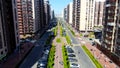 Aerial of people walking down the green alley in the summer city street. Motion. Flying along the road with buildings