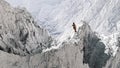 Aerial perspective of hiker standing on peak in snow.