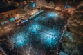 Aerial perspective of roller skaters circling an old-fashioned outdoor roller rink set under a sea of twinkling stars on a clear