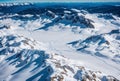 Aerial perspective of snowy alpine mountains with ski tracks. AI generated.