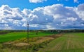 Aerial perspective view on rural landscape with house, forest, clouds, fields and electric power line tower Royalty Free Stock Photo