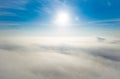 Aerial photo above the fog or white clouds with shining sun. Beautiful sunrise cloudy sky from aerial view. Above clouds from