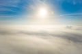 Aerial photo above the fog or white clouds with shining sun. Beautiful sunrise cloudy sky from aerial view. Above clouds Royalty Free Stock Photo