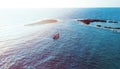 Aerial photo above rock outcrop and reef in crystal clear warm water.