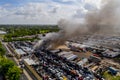 Aerial photo of a fire at a car junk yard firefighters water hosing flames extinguishing