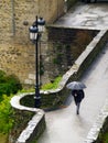 Aerial photo of a medieval bridge and a person with an umbrella