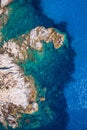 Aerial photo over granite rocky coastline Mediterranean crystal clear blue sea water. Aerial photo of ocean waves hitting rocky Royalty Free Stock Photo