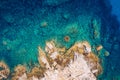 Aerial photo over granite rocky coastline Mediterranean crystal clear blue sea water. Aerial photo of ocean waves hitting rocky Royalty Free Stock Photo