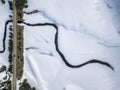 Aerial photo over winter mountain. Meandering river in show field near road.. Royalty Free Stock Photo