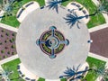 Aerial photo of a roundabout in a shopping center in Brentwood, California with palm trees, foundation and cars