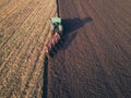 Aerial photo of a tractor ploughing a field in a countryside