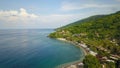 Aerial photo of a wild beach in Bali. A long strip of beach and a steep mountain slope covered with greenery. Wild beach in Bali Royalty Free Stock Photo