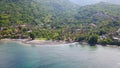 Aerial photo of a wild beach in Bali. A long strip of beach and a steep mountain slope covered with greenery. Wild beach in Bali Royalty Free Stock Photo