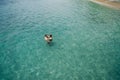 Aerial photo of young couple on holidays swimming in ocean