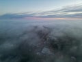 Aerial photograph capturing the ethereal beauty of a city shrouded in mist during twilight