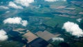 Aerial photograph of a pattern of fields, valleys and villages with cloud sky taken out of an aeroplane