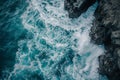 In this aerial photograph, the powerful waves of the ocean crash forcefully against the sturdy rocks, High aerial angle of a rough