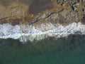 Aerial photograph of a rocky coastline with arriving and breaking ocean waves
