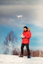 Aerial photography and drone footage details with attractive caucasian man operating drone, flying over blue sky