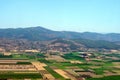 Aerial photography. View from the plane`s window: mountains on the horizon, green fields and meadows below. Royalty Free Stock Photo