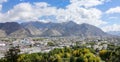 AERIAL: Picturesque view of the city of Lhasa under the rocky mountains of Tibet Royalty Free Stock Photo