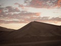 Aerial postcard panorama sunset view of isolated lonely single man person on dry sand dune desert of Huacachina Ica Peru Royalty Free Stock Photo